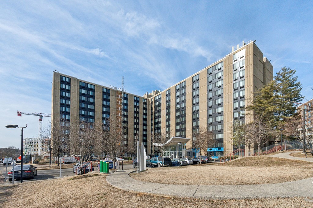 Exterior view of Edgewood Commons 611 & Gardens, a modern high-rise and garden-style apartment community in Northeast Washington, D.C., offering market-rate 1- and 2-bedroom homes. The building features landscaped grounds, convenient access to public transportation, and a welcoming atmosphere near Rhode Island and Brookland Metro stations.