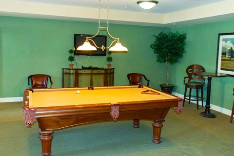 a pool table in a room with a green wall