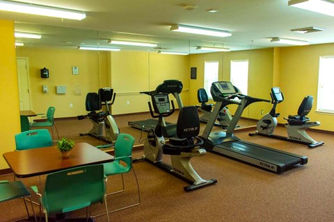 a gym with a lot of machines and chairs
