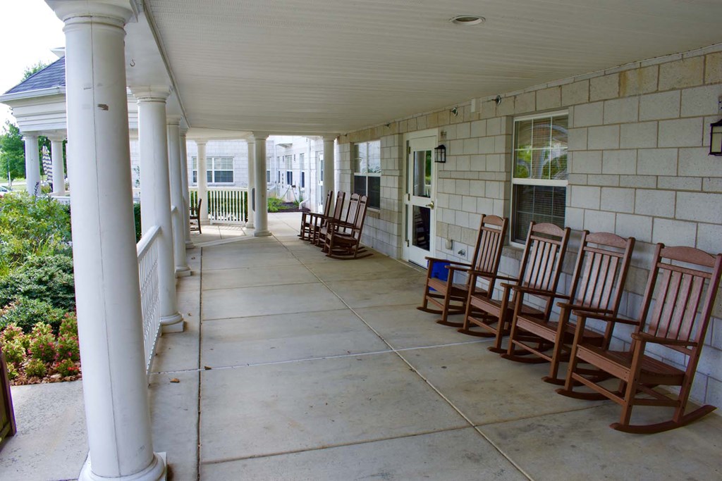 the covered porch has rocking chairs on it