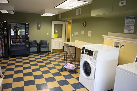 Laundry room with a washer, dryer, and vending machine.