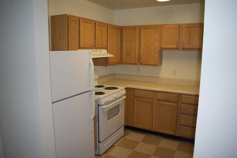 Kitchen with a white refrigerator and a white stove top oven.