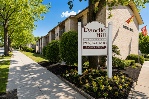 A sign for Randle Hill Apartments stands in front of apartment buildings.