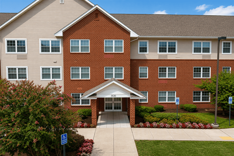 A red brick building with a covered walkway leading to the entrance.