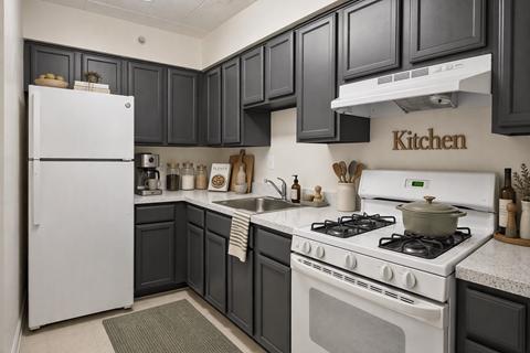 A kitchen with a white refrigerator and a white stove top oven.