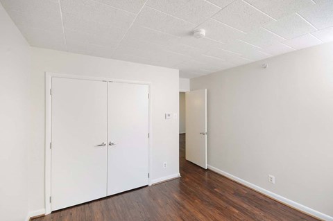 Comfortable bedroom with large closet and stylish vinyl plank flooring in a market-rate apartment at Edgewood Commons 601—ideal for residents seeking affordable luxury in Washington, DC.
