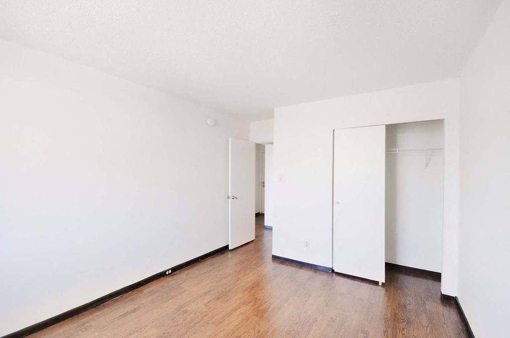 spacious bedroom with large closet and wood floors