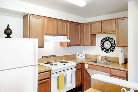 a kitchen with white appliances and wooden cabinets