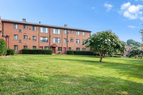 Exterior view of Meadowbrook Run Apartments, an Enterprise community in Congress Heights, Washington, D.C., surrounded by mature trees and green space, showcasing a peaceful park-like setting