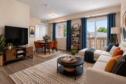A living room with a flat screen TV, a coffee table, and a couch with throw pillows.