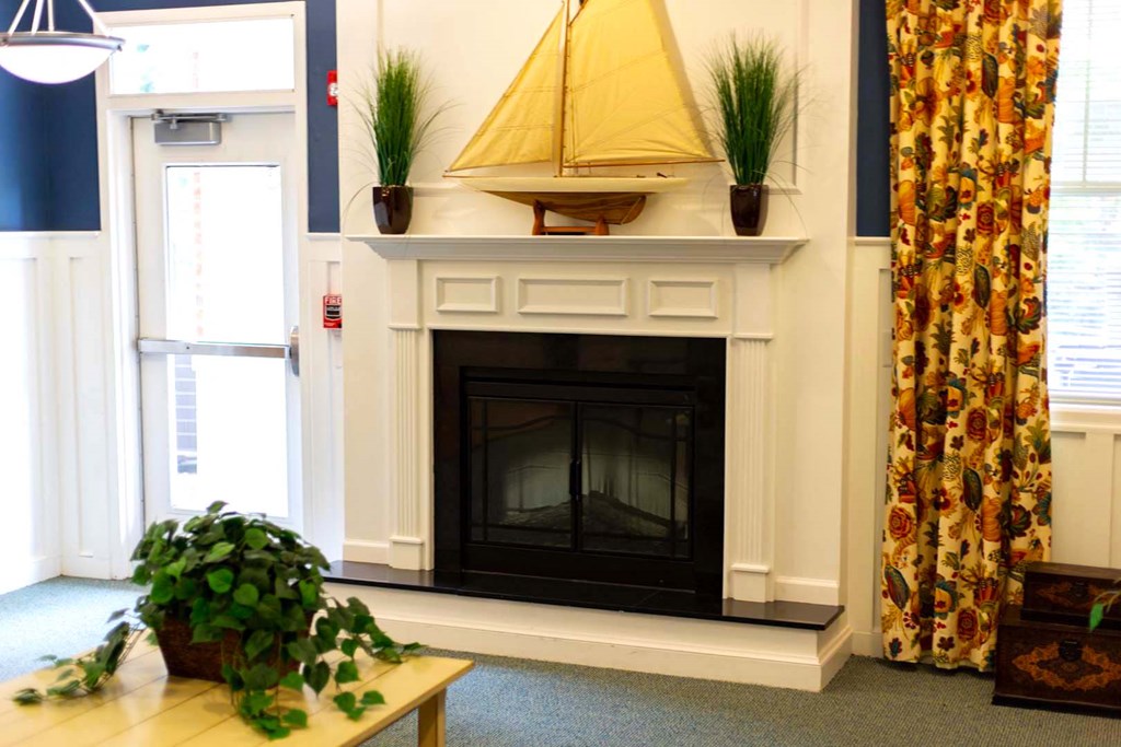 a fireplace in a living room with a sailboat on top of it