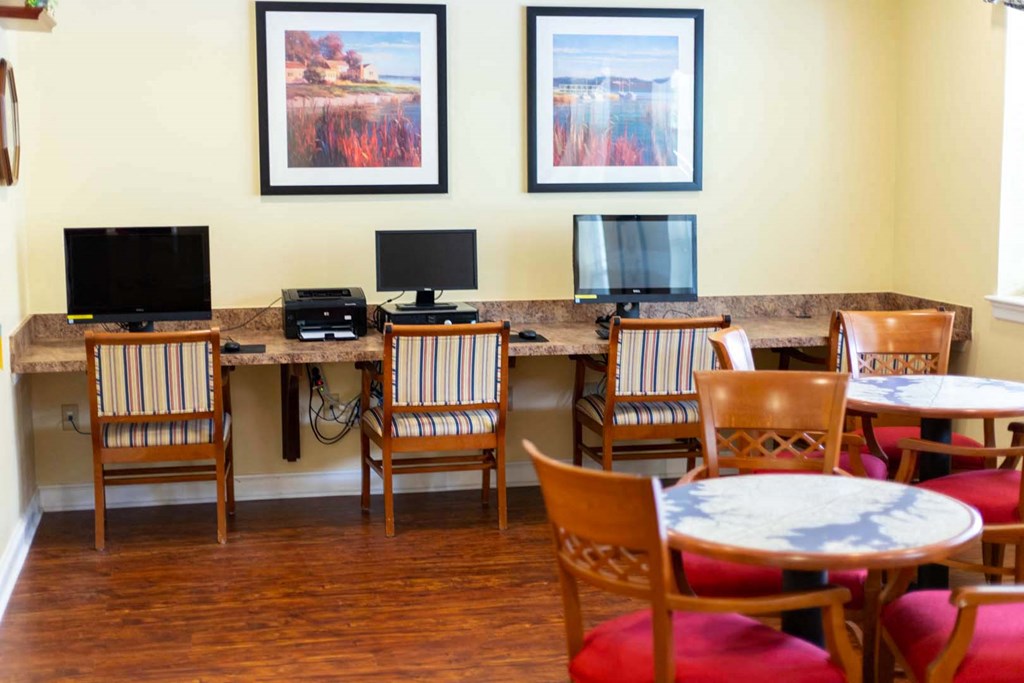 a computer room with tables and chairs and computers