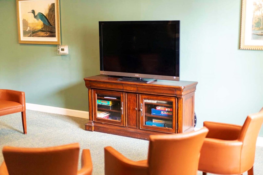 a living room with a tv and chairs