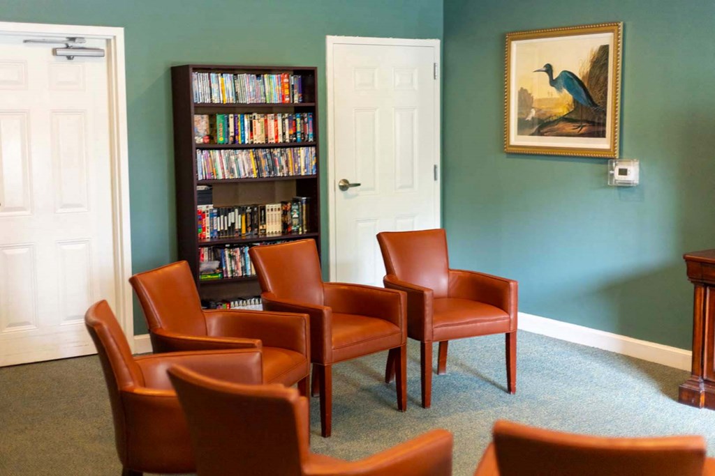 a group of chairs in a room with a book shelf