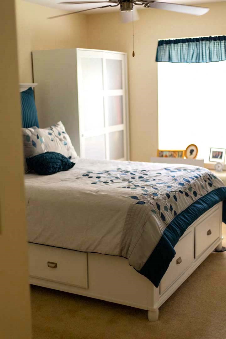 a bed with a blue and white comforter on it
