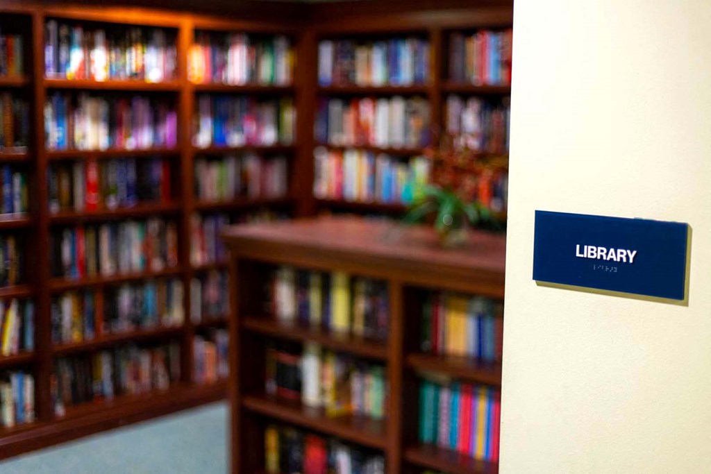 a library sign in front of shelves of books
