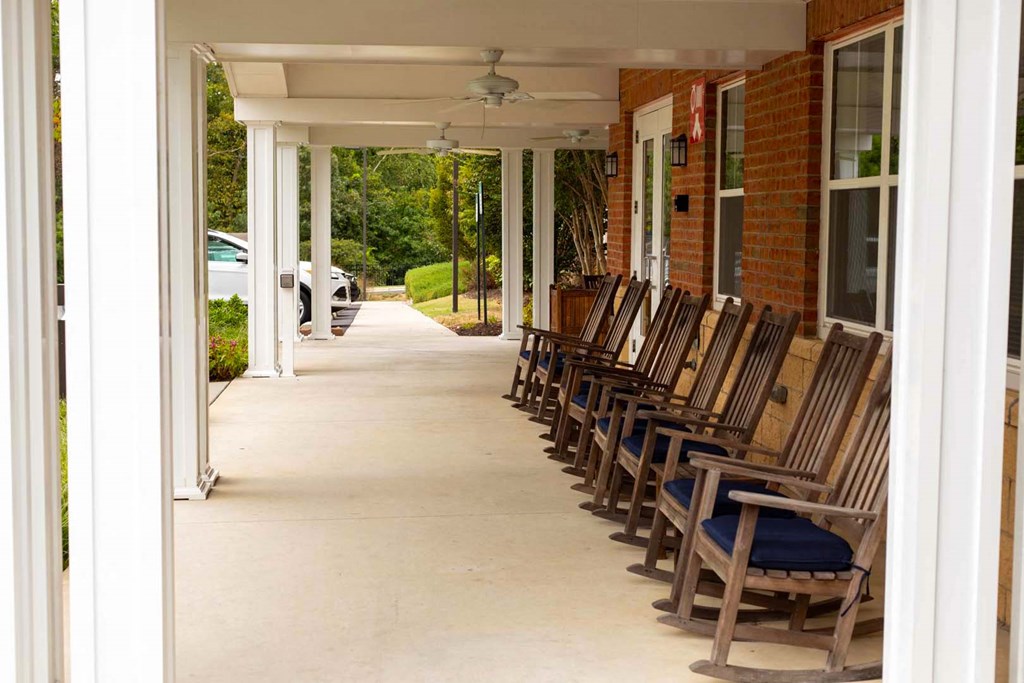 a row of wooden chairs sitting outside of a building