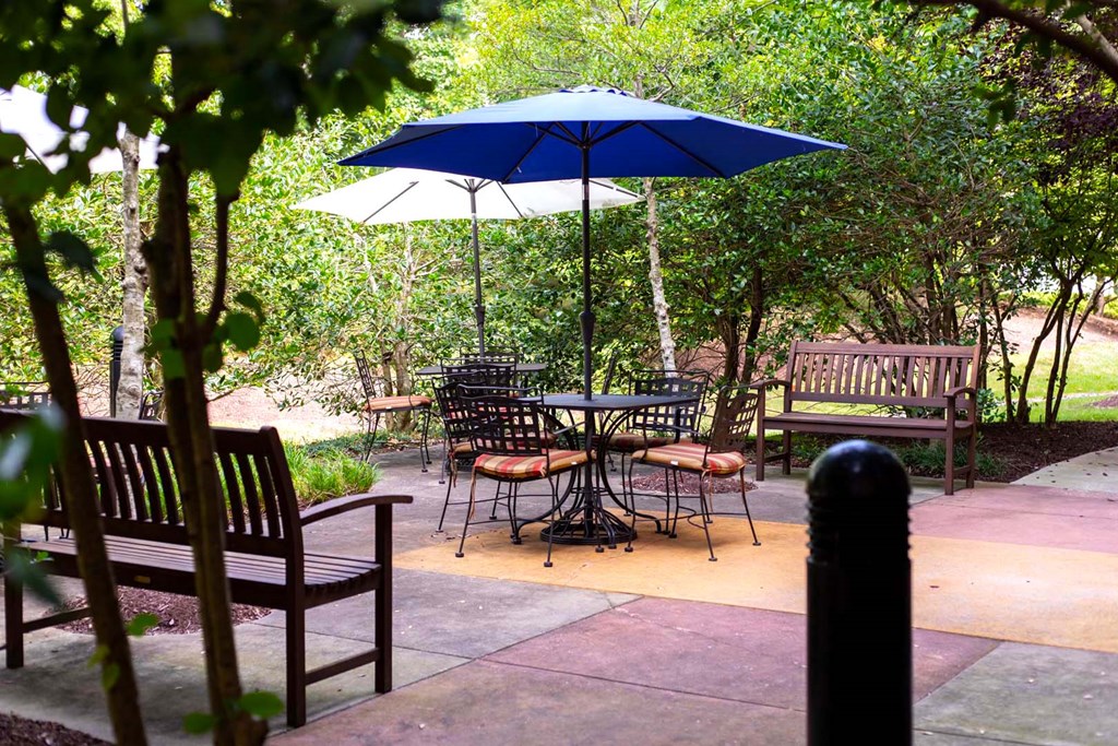 a patio with tables and chairs and umbrellas