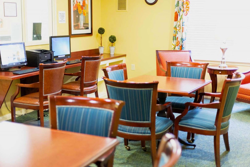a dining room with tables and chairs and a computer