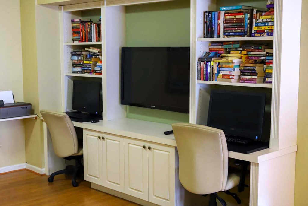 a home office with two chairs and a desk with a tv