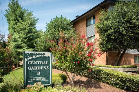 a sign for the central gardens ii apartments in front of a building