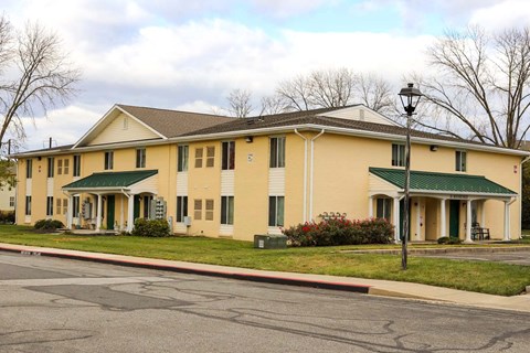 the front of a yellow building with a street
