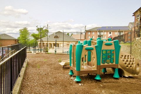 a playground at a school with a building in the background