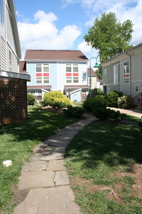 a walkway between two houses in a yard