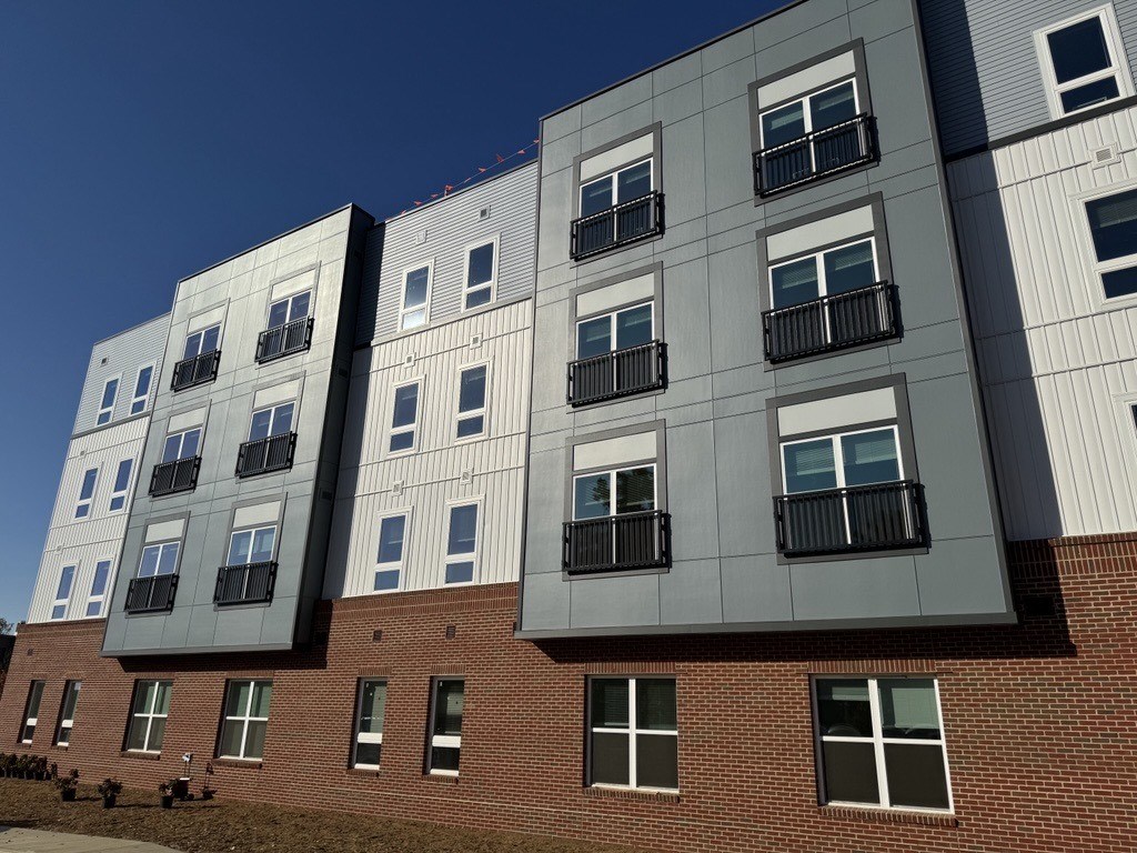 A modern building with a mix of brick and panel construction.