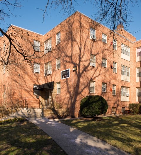 a brick building with a tree casting a shadow on it