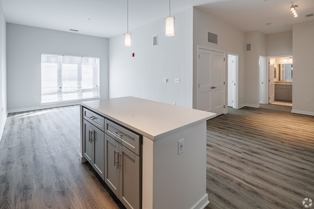 an empty kitchen with a white counter top in a new home