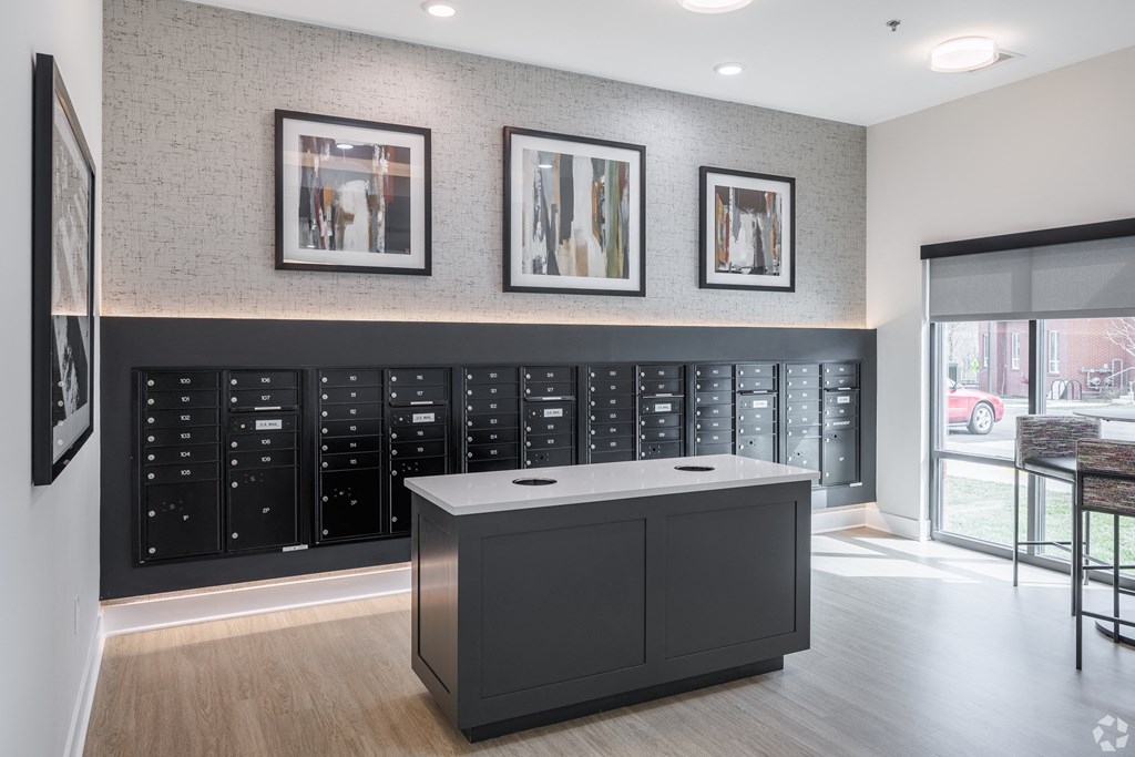 an island in the middle of a room with a black cabinet and a wall with