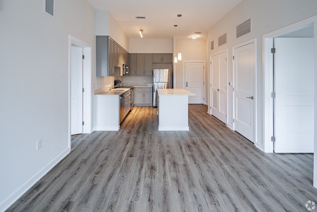 an empty living room and kitchen with a wood floor