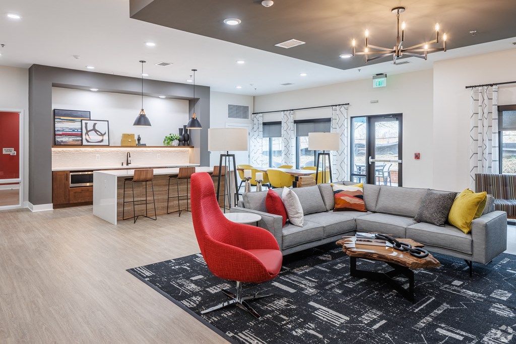a living room with a gray couch and a red chair