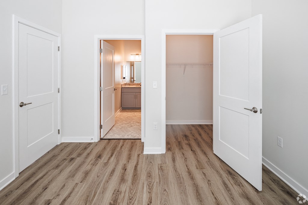 a renovated living room with white doors and a hallway to a bedroom and a bathroom