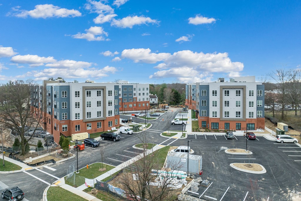 an aerial view of an empty parking lot in front of an apartment building