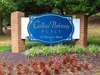 a sign for college parkway place in front of flowers