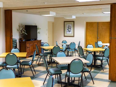 a dining room with tables and chairs and a tv
