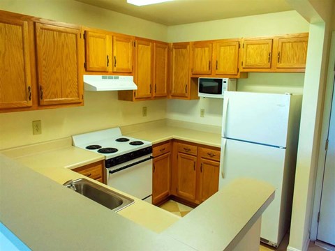 a kitchen with white appliances and wooden cabinets