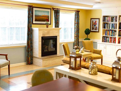 a living room with a fireplace and a table and chairs