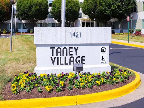a sign with flowers in front of a building