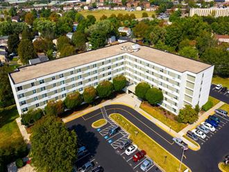 large white building with a parking lot in front of it - Photo Gallery