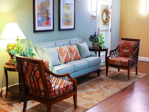 a living room with a blue couch and two chairs