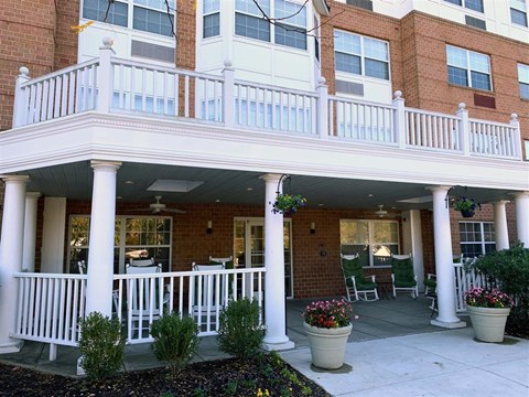 the front porch of an apartment building with a porch swing