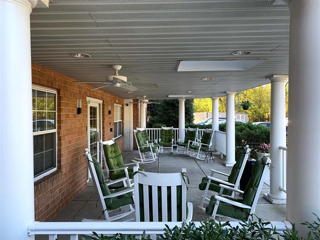 a covered porch with rocking chairs and rocking chairs