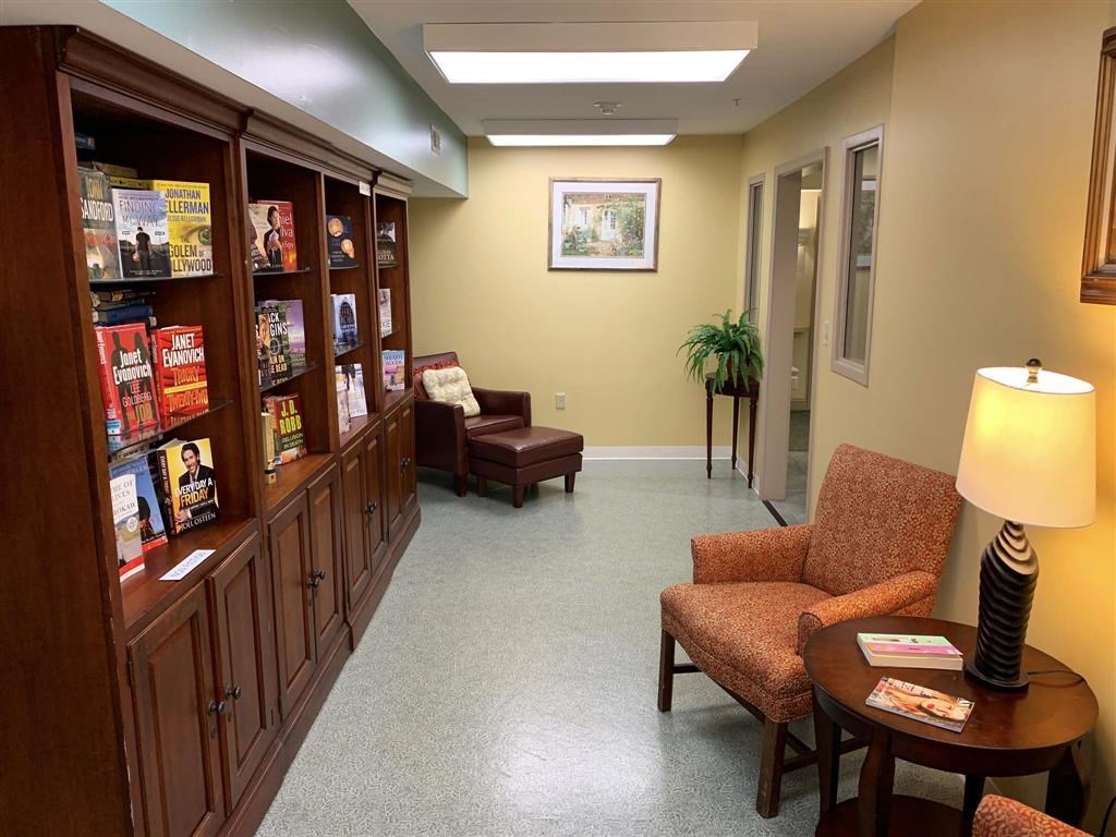 a waiting room at a hospital with chairs and a bookshelf