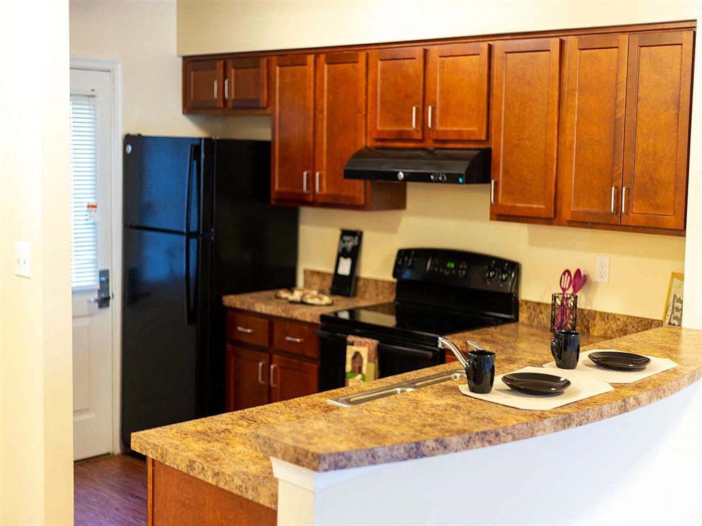 a kitchen with a granite counter top and a black refrigerator
