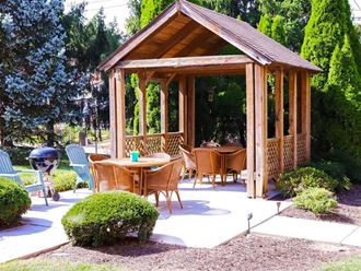a patio with a gazebo and a table and chairs