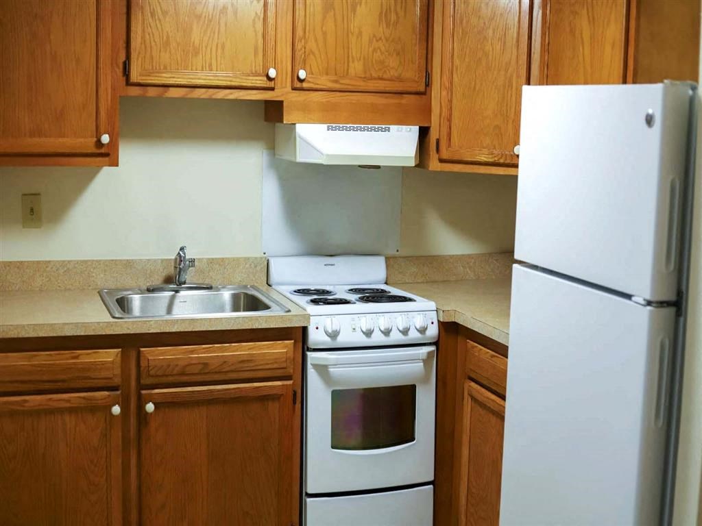 a kitchen with white appliances and wooden cabinets
