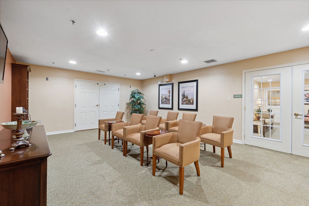 a room with a row of chairs in front of a tv